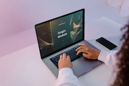Person using a laptop with 'Origin Module' Swift PDF course on the screen, sitting at a desk.